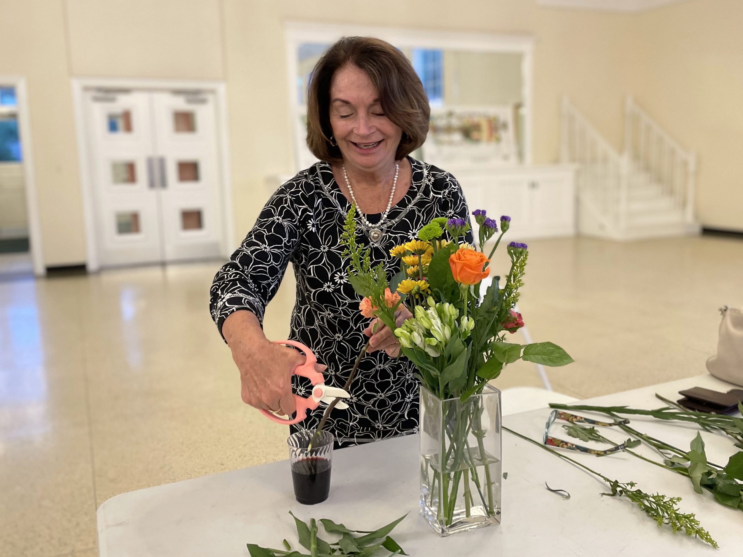 A guests cuts flowers for a flower arrangement