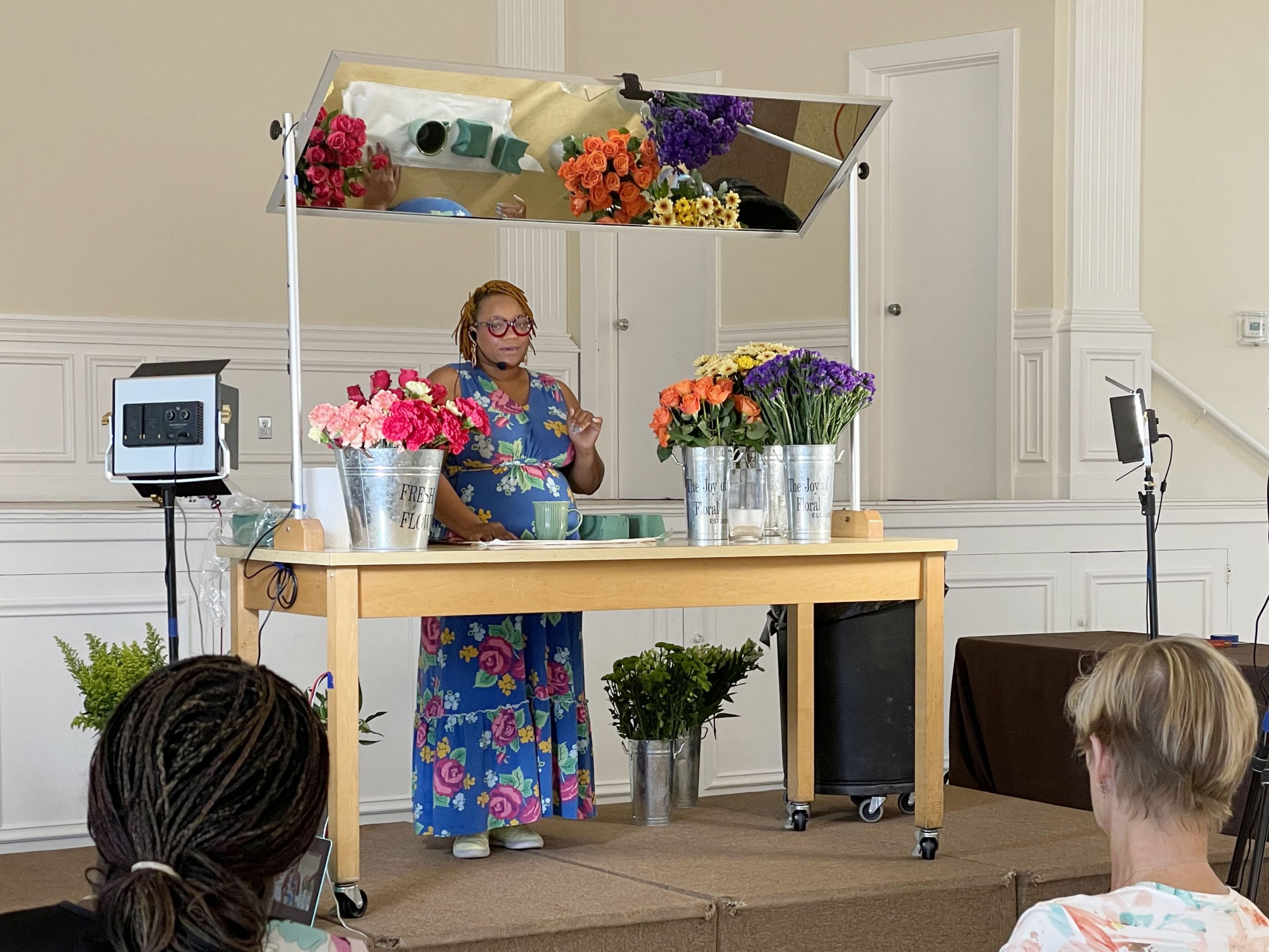 The instructor demonstrates flower arranging on stage